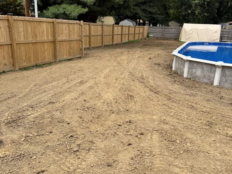 Graded back yard shaped to fall away from a fence line and pool