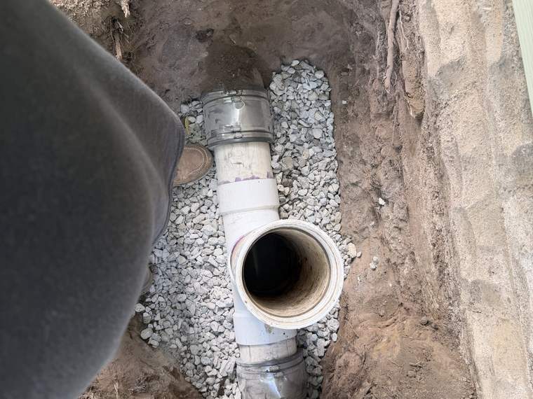 Drain basin and pipe tie in bedded in stone in an open excavation