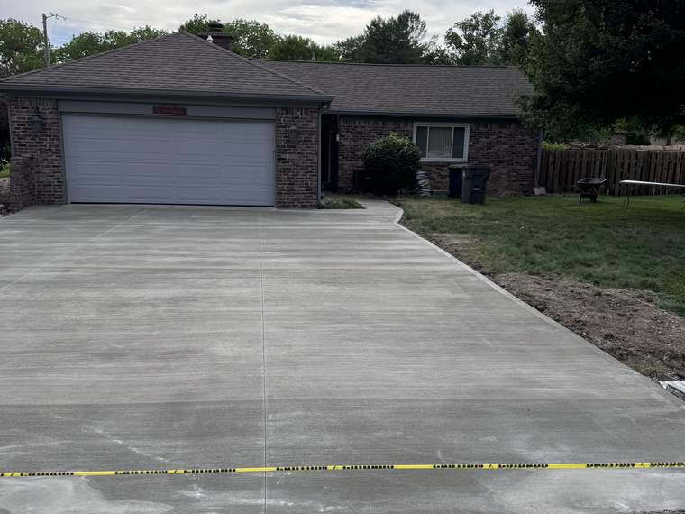 Finished poured concrete driveway running from the street to a two car garage