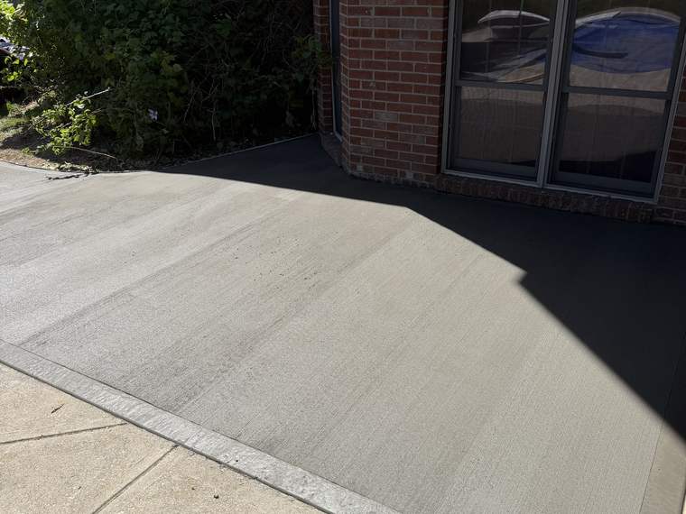 Finished concrete pad poured against the back of a brick home