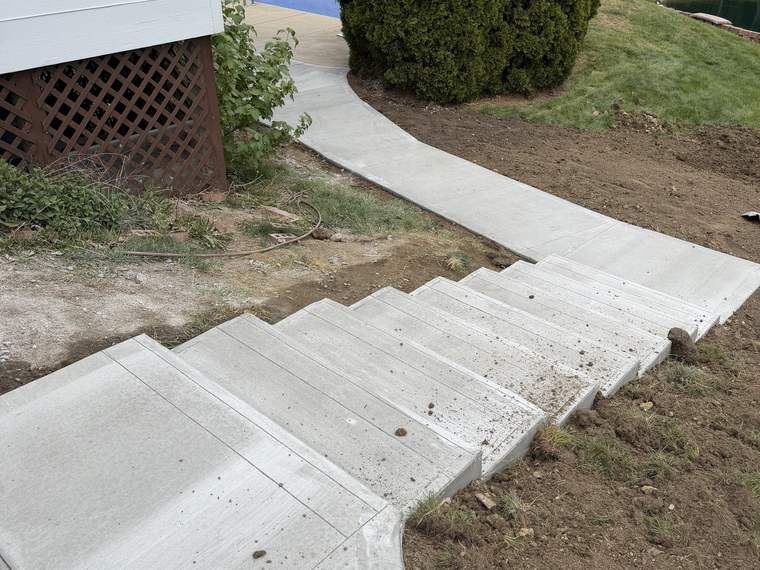 New concrete steps and walkway poured at the side of a home