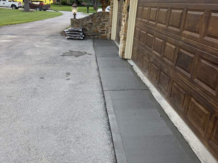Concrete strip poured alongside a garage to widen the drive