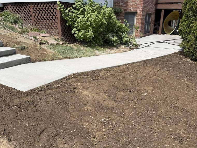 New concrete walk poured with the surrounding ground still open