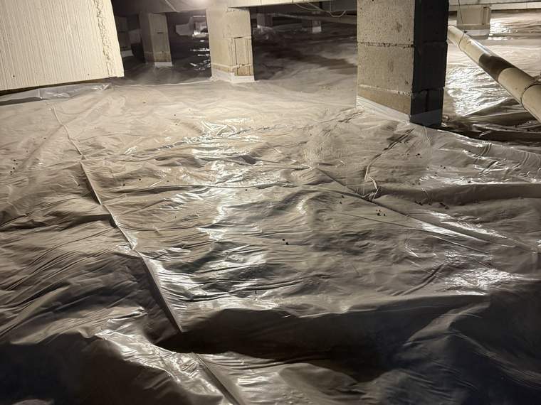 Vapor barrier laid across the floor of a crawlspace