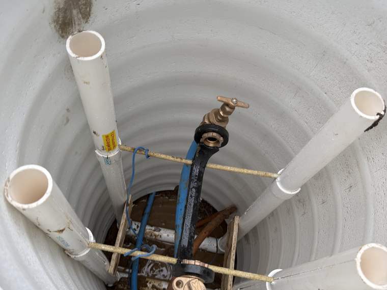 Inside a new water meter pit with the meter, valves and service lines set