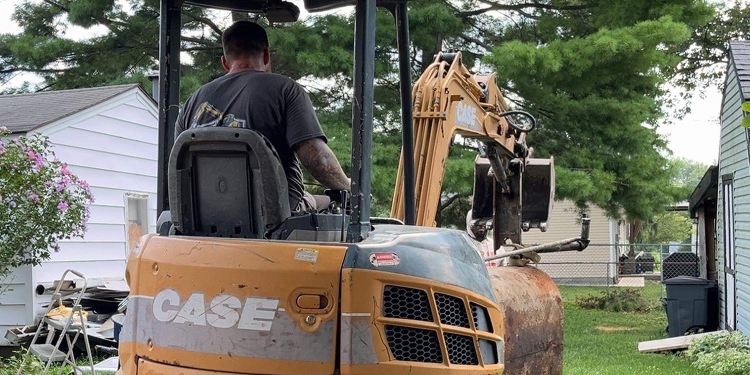 Sterling's operator running a compact excavator on a residential job site