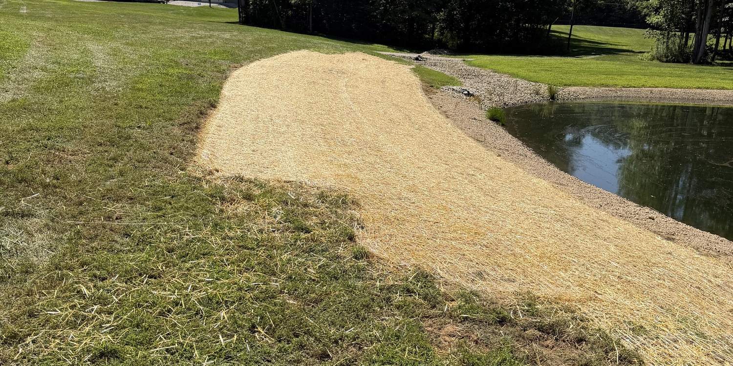 Pond bank graded, seeded and strawed down to the waterline