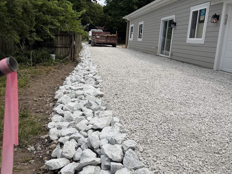 Rip rap channel installed alongside a new gravel driveway to carry runoff
